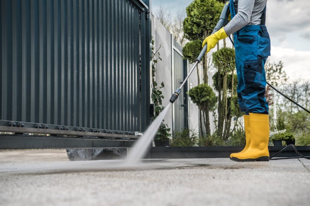 man pressure washing the driveway