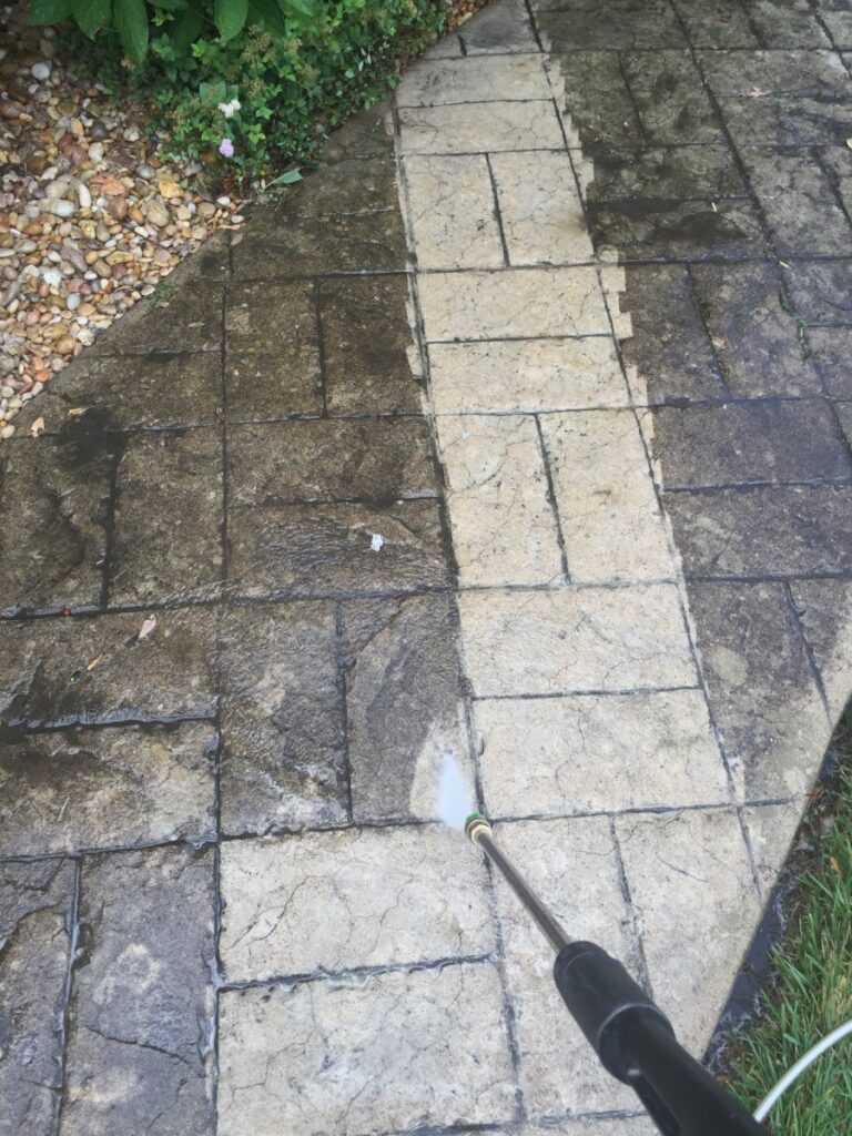 person pressure washing sidewalk